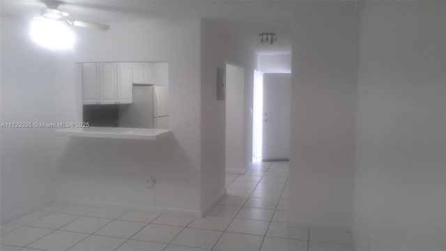 corridor featuring light tile patterned flooring and electric panel