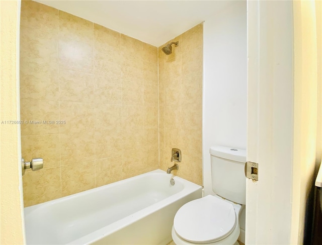 bathroom with toilet and tiled shower / bath combo