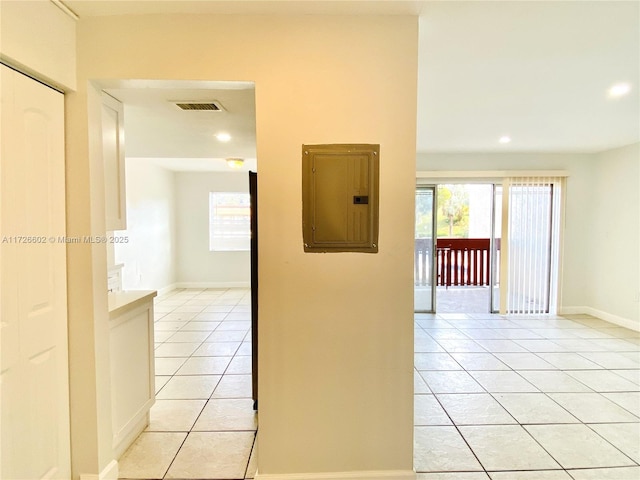 corridor featuring light tile patterned flooring and electric panel