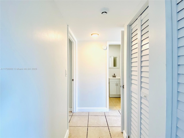 corridor with light tile patterned flooring and sink