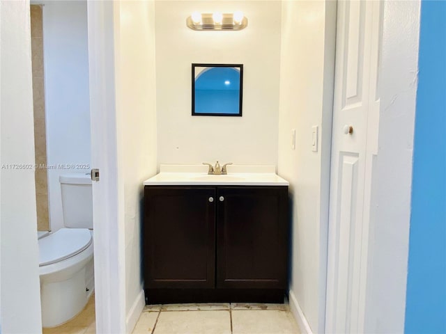 bathroom with toilet, vanity, and tile patterned flooring