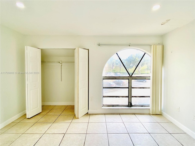 unfurnished bedroom with light tile patterned floors and a closet