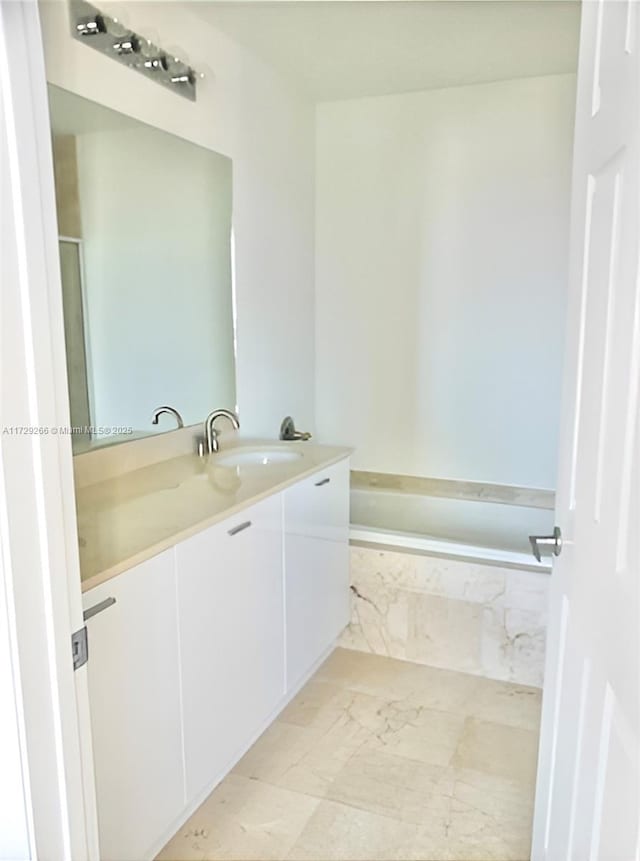 bathroom featuring vanity, tile patterned floors, and a relaxing tiled tub