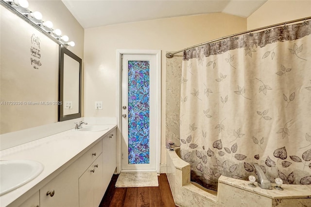 bathroom with a shower with curtain, wood-type flooring, vaulted ceiling, and vanity