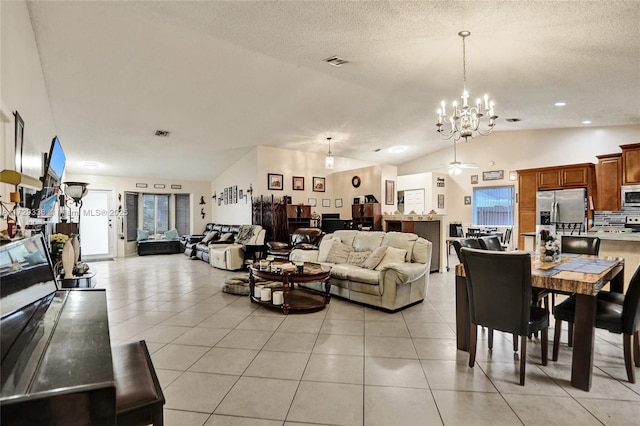 tiled living room with lofted ceiling, a wealth of natural light, and a textured ceiling