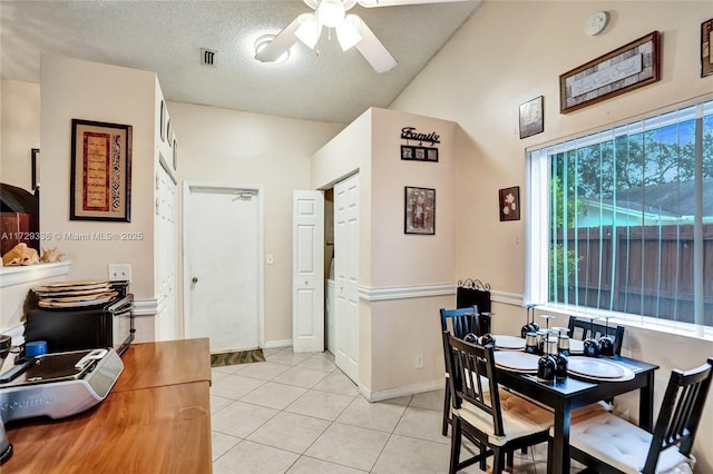 dining room with ceiling fan, a textured ceiling, and light tile patterned floors