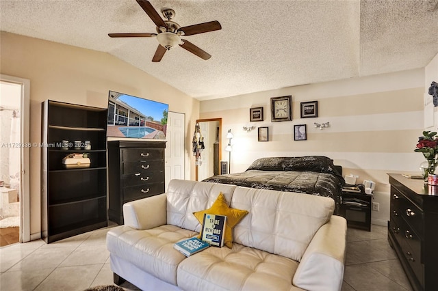 bedroom featuring light tile patterned floors, ceiling fan, ensuite bathroom, a textured ceiling, and vaulted ceiling