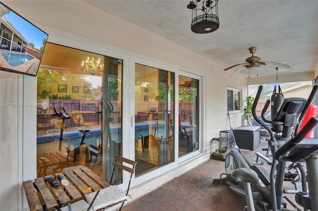 workout area featuring ceiling fan, carpet, and a textured ceiling