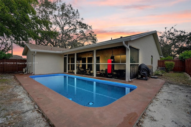 pool at dusk with a patio