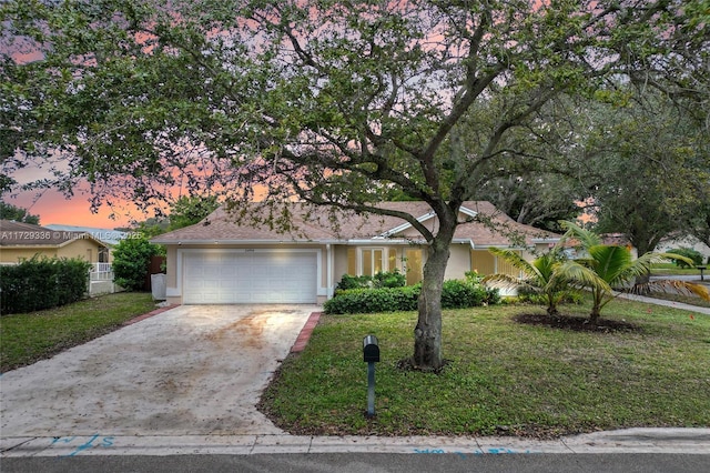 ranch-style home with a garage and a lawn