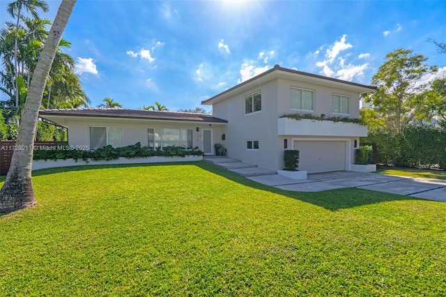 rear view of house with concrete driveway, a lawn, an attached garage, and stucco siding