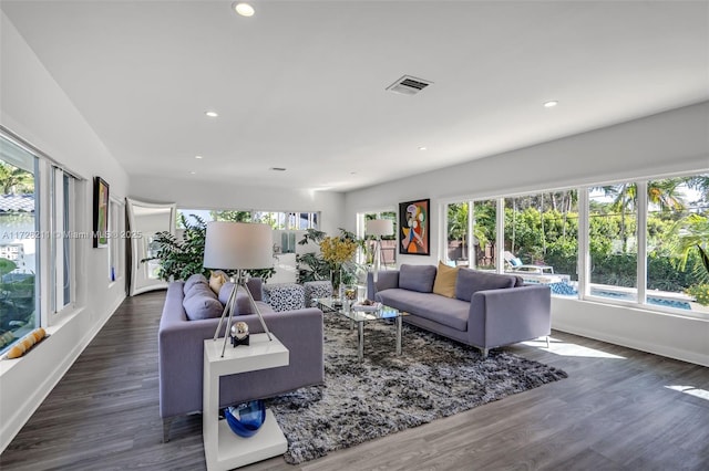 living area with dark wood-type flooring and recessed lighting