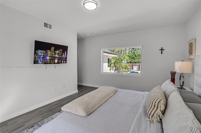 bedroom with baseboards, visible vents, and dark wood-type flooring