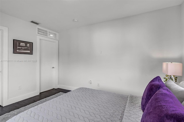 bedroom featuring dark wood finished floors, visible vents, and baseboards