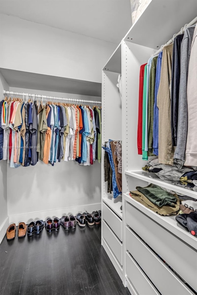 walk in closet with dark wood-type flooring