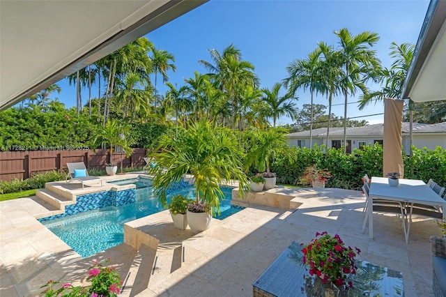 view of swimming pool featuring a patio area, fence, a fenced in pool, and an in ground hot tub