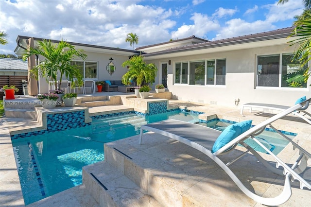 back of property with an outdoor pool, stucco siding, a patio area, and a hot tub