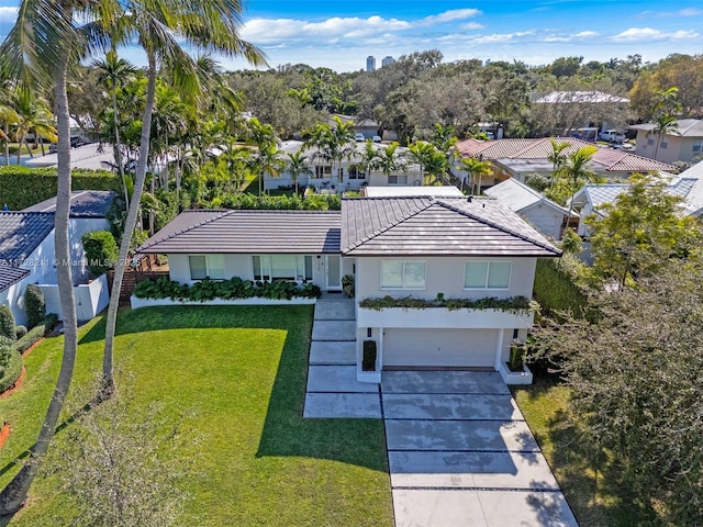 view of front of house featuring a garage, driveway, a front yard, and a residential view