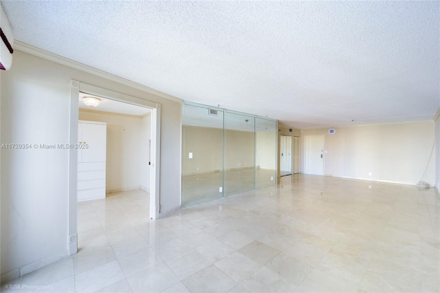 empty room featuring a textured ceiling and ornamental molding