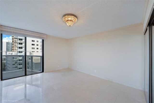 empty room featuring a textured ceiling and crown molding