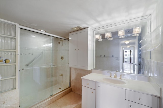 bathroom with tile patterned flooring, a shower with shower door, and vanity