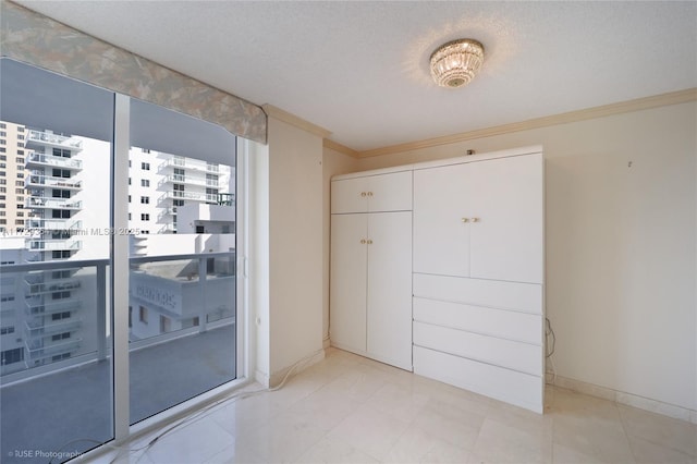 interior space featuring a closet, a textured ceiling, and ornamental molding