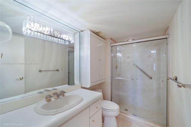 bathroom with toilet, vanity, and a shower with shower door