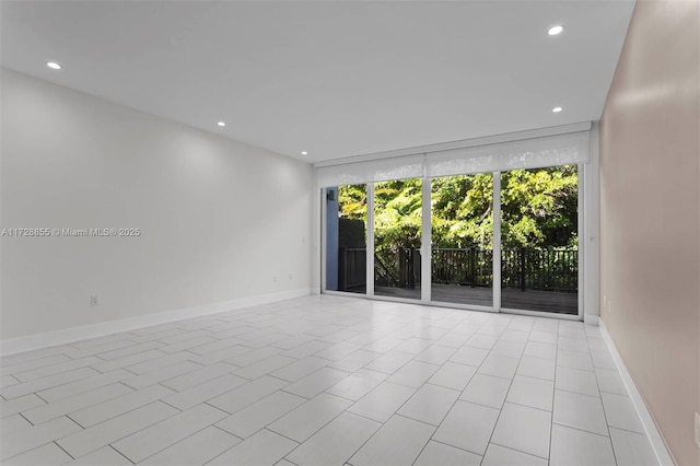 tiled spare room with a wall of windows