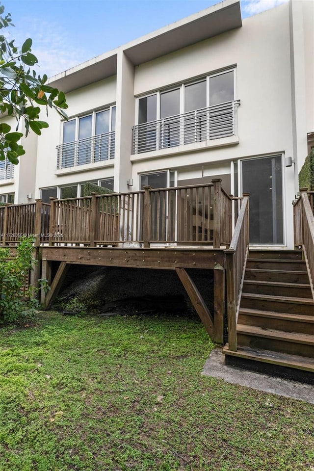 back of house with a deck and a yard