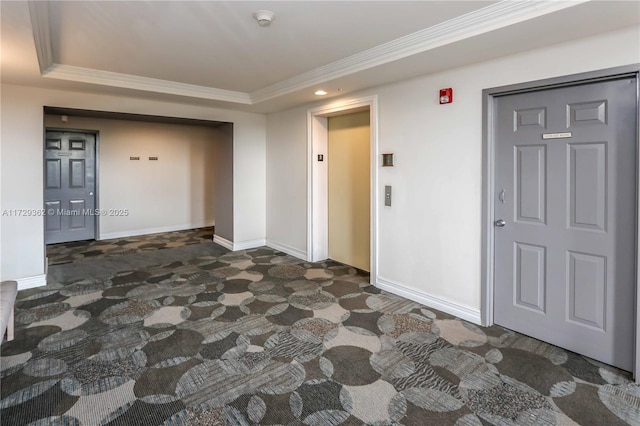 spare room featuring ornamental molding, a tray ceiling, and elevator