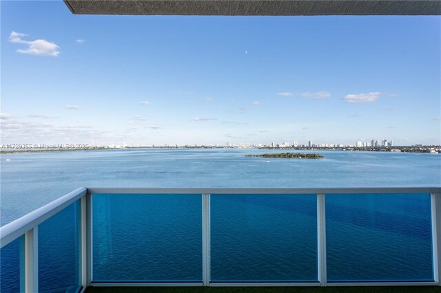 700 NE 25th St Unit 1003, Miami, FL 33137 - kitchen with sink, hanging light fixtures, wall chimney exhaust hood, and dark stone counters