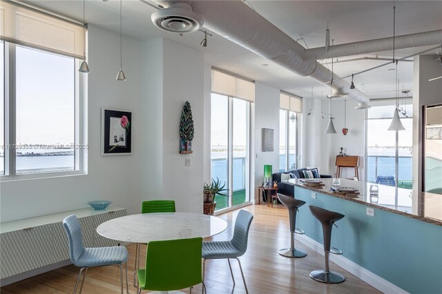 700 NE 25th St Unit 1003, Miami, FL 33137 - dining area featuring a water view, floor to ceiling windows, and light wood-type flooring