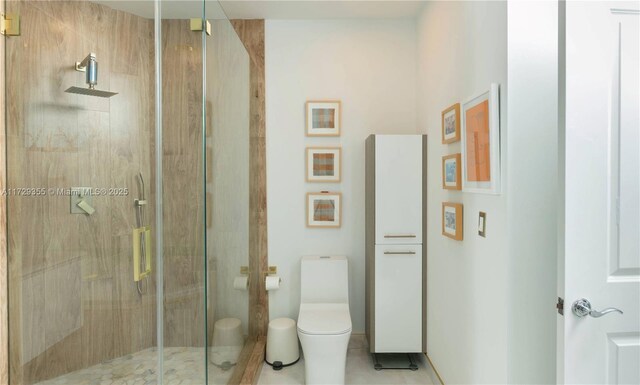 bathroom featuring toilet and a shower with shower door