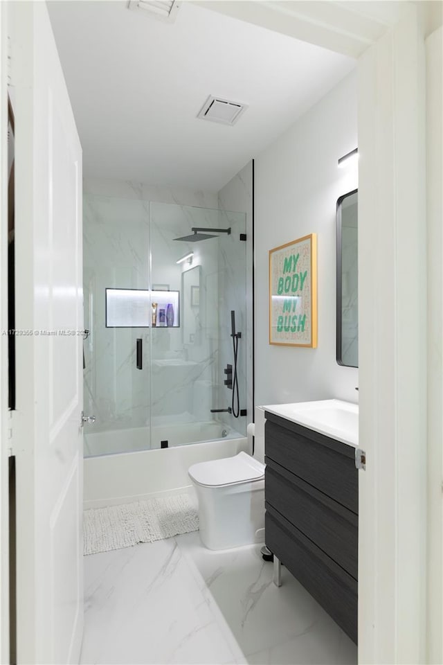 full bathroom with combined bath / shower with glass door, vanity, and toilet