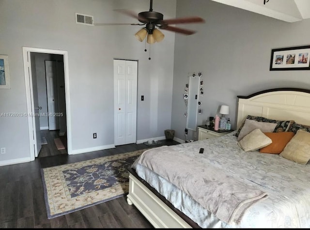 bedroom with ceiling fan, dark hardwood / wood-style floors, high vaulted ceiling, and a closet