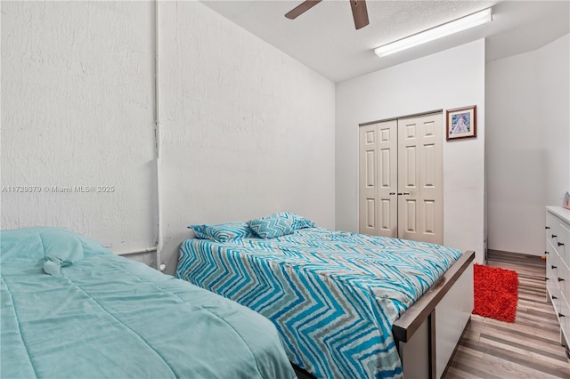 bedroom featuring light wood-type flooring, a closet, lofted ceiling, and ceiling fan