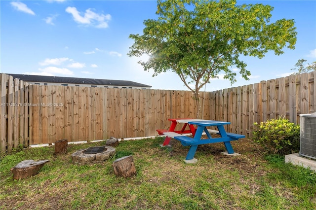 view of yard featuring central air condition unit and a fire pit