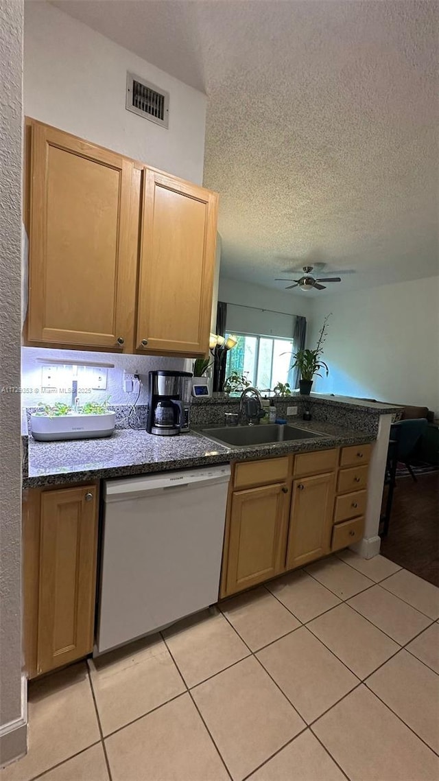 kitchen featuring ceiling fan, light tile patterned flooring, dishwasher, a textured ceiling, and sink