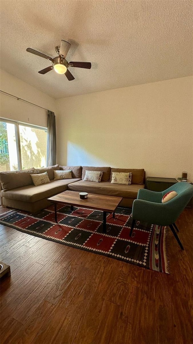 living room with ceiling fan, a textured ceiling, and hardwood / wood-style floors