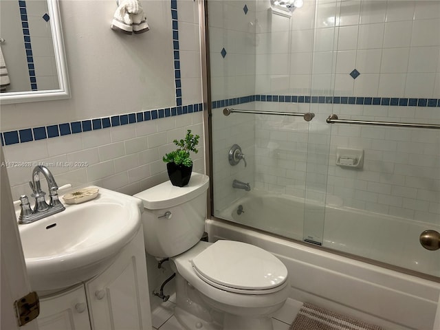 full bathroom with tile walls, vanity, shower / bath combination with glass door, and toilet