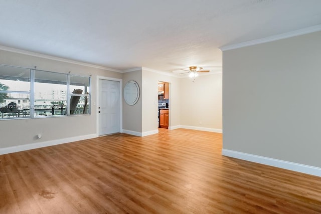 unfurnished living room featuring crown molding, a ceiling fan, light wood-style flooring, and baseboards