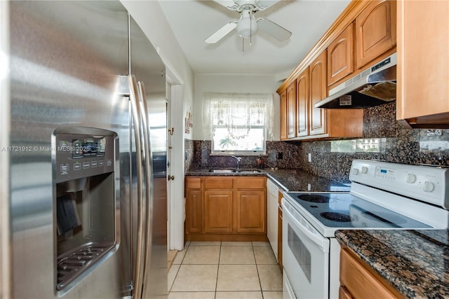 250 Layne Blvd Unit 312, Hallandale Beach, FL 33009 - kitchen with white appliances, under cabinet range hood, brown cabinetry, dark stone counters, and backsplash