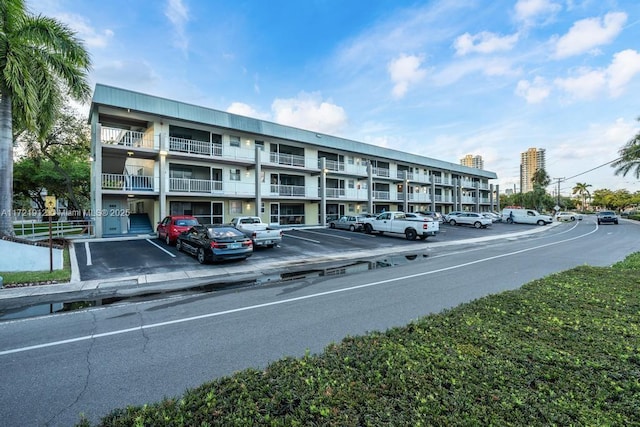 view of property with uncovered parking and a view of city