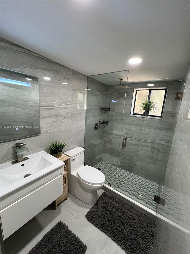 bathroom with toilet, tile walls, walk in shower, and vanity