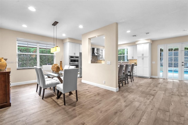 dining space with light hardwood / wood-style floors and a healthy amount of sunlight