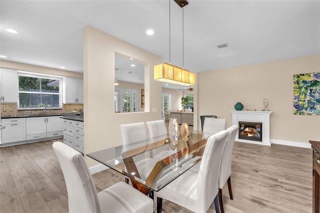 dining space featuring sink and light hardwood / wood-style flooring