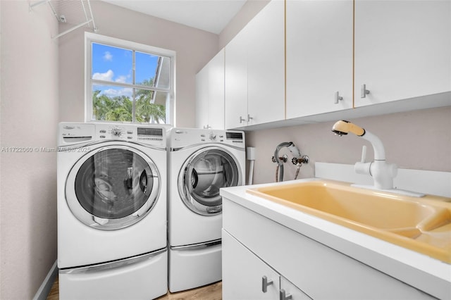 laundry room featuring sink, independent washer and dryer, and cabinets