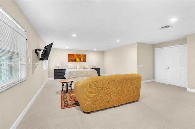 bedroom with light colored carpet and a closet