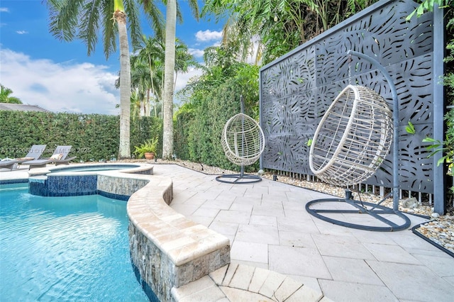 view of swimming pool with an in ground hot tub and a patio area