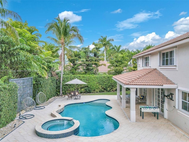 view of pool featuring a patio area and an in ground hot tub